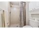 Tiled shower with curtain, cabinets, and toilet in this well-kept bathroom at 12141 Spartan Way # 102, Hudson, FL 34667