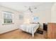 Bright bedroom with wood flooring, ceiling fan, and large window for natural light at 12141 Spartan Way # 102, Hudson, FL 34667