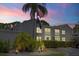 Exterior of a well-maintained building with garden and American flag at 12141 Spartan Way # 102, Hudson, FL 34667