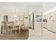 Bright dining room featuring a glass display cabinet and an adjacent kitchen with white appliances at 12141 Spartan Way # 102, Hudson, FL 34667