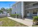 Exterior view of condo building with light blue siding, white trim, second story balcony, and manicured bushes at 12141 Spartan Way # 102, Hudson, FL 34667