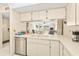 Bright kitchen featuring white cabinets, a breakfast bar, and an open view to the living and dining areas at 12141 Spartan Way # 102, Hudson, FL 34667