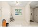 Bright, simple kitchen nook with white tile flooring and a window with green views at 12141 Spartan Way # 102, Hudson, FL 34667