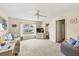 Living room with neutral carpet, ceiling fan, and sliding door to the lanai at 12141 Spartan Way # 102, Hudson, FL 34667