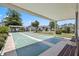 Outdoor shuffleboard court under a covered patio, surrounded by lush landscaping at 12141 Spartan Way # 102, Hudson, FL 34667