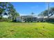 Expansive backyard with well-maintained lawn, landscaping, and screened-in pool area for outdoor enjoyment at 14178 Pullman Dr, Spring Hill, FL 34609