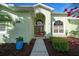Close up of the facade featuring a red double door entrance, well-maintained landscaping, and bright exterior paint at 14178 Pullman Dr, Spring Hill, FL 34609