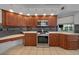 Beautiful kitchen boasts stainless steel appliances, light countertops, and wood cabinetry at 14178 Pullman Dr, Spring Hill, FL 34609
