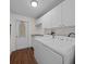 This laundry room features a modern washer and dryer, lots of cabinet storage, and tile floors at 14178 Pullman Dr, Spring Hill, FL 34609