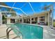 Relax in this screened-in pool area, featuring a spacious patio, outdoor seating, and serene views at 14178 Pullman Dr, Spring Hill, FL 34609