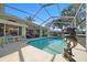This screened-in pool area offers a relaxing retreat with dolphin statue, patio, and serene backyard views at 14178 Pullman Dr, Spring Hill, FL 34609