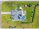 Aerial view of home with a screened pool, lush landscaping, and solar panels at 1478 Brigadier Dr, Spring Hill, FL 34608