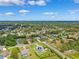 Wide aerial shot of a neighborhood, featuring a home with a pool and solar panels surrounded by verdant landscapes at 1478 Brigadier Dr, Spring Hill, FL 34608