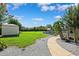 Expansive backyard features stone fireplace, shed, manicured lawn, mature trees and greenery at 1478 Brigadier Dr, Spring Hill, FL 34608