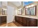 Bathroom features double sinks, a vanity with dark wood cabinets, and warm lighting at 1478 Brigadier Dr, Spring Hill, FL 34608