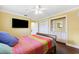 A cozy bedroom with a colorful quilt, ceiling fan, and built-in storage at 1478 Brigadier Dr, Spring Hill, FL 34608