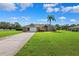 Charming single-story home with a well-manicured lawn and a palm tree in the front yard at 1478 Brigadier Dr, Spring Hill, FL 34608
