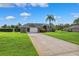 Charming single-story home with a well-manicured lawn, a long driveway, and an attached two-car garage at 1478 Brigadier Dr, Spring Hill, FL 34608