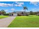 Welcoming single-story home featuring a two-car garage, long driveway, and verdant front lawn at 1478 Brigadier Dr, Spring Hill, FL 34608