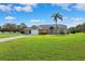 Inviting single-story home with an attached garage, a long driveway, and beautiful landscaping on a sunny day at 1478 Brigadier Dr, Spring Hill, FL 34608