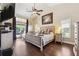 Spacious main bedroom with hardwood floors, a ceiling fan, and direct access to the pool area at 1478 Brigadier Dr, Spring Hill, FL 34608