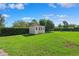 A white shed is surrounded by a well-maintained lawn and lush, green hedges at 1478 Brigadier Dr, Spring Hill, FL 34608