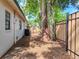 Backyard with tall wooden fence features mature trees and exterior air conditioning unit at 1652 Larkin Rd, Spring Hill, FL 34608