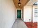 Welcoming front entrance featuring a vibrant green door and stylish overhead lighting at 1652 Larkin Rd, Spring Hill, FL 34608