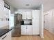 Kitchen showcasing stainless steel refrigerator, white cabinets, and dark countertops at 1652 Larkin Rd, Spring Hill, FL 34608