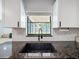 Close-up of kitchen sink featuring stylish faucet, window view, and granite countertops at 1652 Larkin Rd, Spring Hill, FL 34608