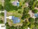 Aerial view of a home with a private pool surrounded by lush greenery and neighboring homes at 2111 Maximilian Ave, Spring Hill, FL 34609