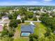 An aerial view of a house with a screened-in pool surrounded by lush greenery in a serene neighborhood at 2111 Maximilian Ave, Spring Hill, FL 34609