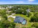 Aerial view showcasing a residential area with mature trees and a home featuring a private pool at 2111 Maximilian Ave, Spring Hill, FL 34609