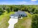 Aerial view of a well maintained home featuring an extended driveway and lush landscaping in a suburban setting at 2111 Maximilian Ave, Spring Hill, FL 34609