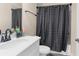 Neutral bathroom featuring a white vanity, toilet, and tiled shower with black fixtures at 2111 Maximilian Ave, Spring Hill, FL 34609