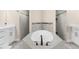Well-lit bathroom featuring a modern soaking tub and dual walk-in shower at 2111 Maximilian Ave, Spring Hill, FL 34609