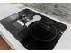 A close-up of a modern induction cooktop on a kitchen island with white countertops and stylish backsplash at 2111 Maximilian Ave, Spring Hill, FL 34609