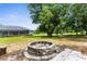 Backyard firepit, large yard, trees, and view of house at 2111 Maximilian Ave, Spring Hill, FL 34609