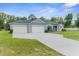 Beautiful home featuring a well-manicured lawn, a three car garage and an inviting front porch at 2111 Maximilian Ave, Spring Hill, FL 34609