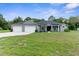 Charming single Gathering home featuring a well-manicured lawn, 3-car garage and inviting front porch at 2111 Maximilian Ave, Spring Hill, FL 34609