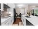 Modern kitchen featuring white cabinetry, stainless steel appliances, and a breakfast bar overlooking the dining area at 2111 Maximilian Ave, Spring Hill, FL 34609