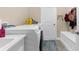Bright laundry room with a sink, washer, dryer, and storage bench at 2111 Maximilian Ave, Spring Hill, FL 34609