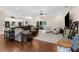 Bright, open living room featuring hardwood floors, a ceiling fan, and sliding doors to the lanai at 2111 Maximilian Ave, Spring Hill, FL 34609