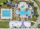 Aerial view of a resort-style pool and amenities with palm trees and lounge chairs at 22289 Nebula Way, Land O Lakes, FL 34637