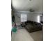 Comfortable living room features a large sectional couch, neutral tile flooring, and natural light through the windows at 22289 Nebula Way, Land O Lakes, FL 34637