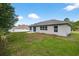 Exterior view of home's backyard featuring a patio and lush lawn at 2476 Magellan Ave, Spring Hill, FL 34608