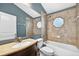 Bathroom featuring decorative tile shower, vanity with countertop, toilet, and a window at 2476 Magellan Ave, Spring Hill, FL 34608
