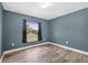 Cozy bedroom featuring wood-look tile flooring, a window with a view, and neutral wall paint at 2476 Magellan Ave, Spring Hill, FL 34608