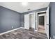 Bedroom featuring wood-look tile flooring, neutral wall paint, closet and a view to the home's hallway at 2476 Magellan Ave, Spring Hill, FL 34608