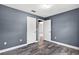 Bedroom featuring wood-look tile flooring, neutral wall paint, and a view to the home's hallway at 2476 Magellan Ave, Spring Hill, FL 34608